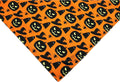 Halloween dog bandana showing reversible pumpkin and spider web patterns with adjustable neck closure