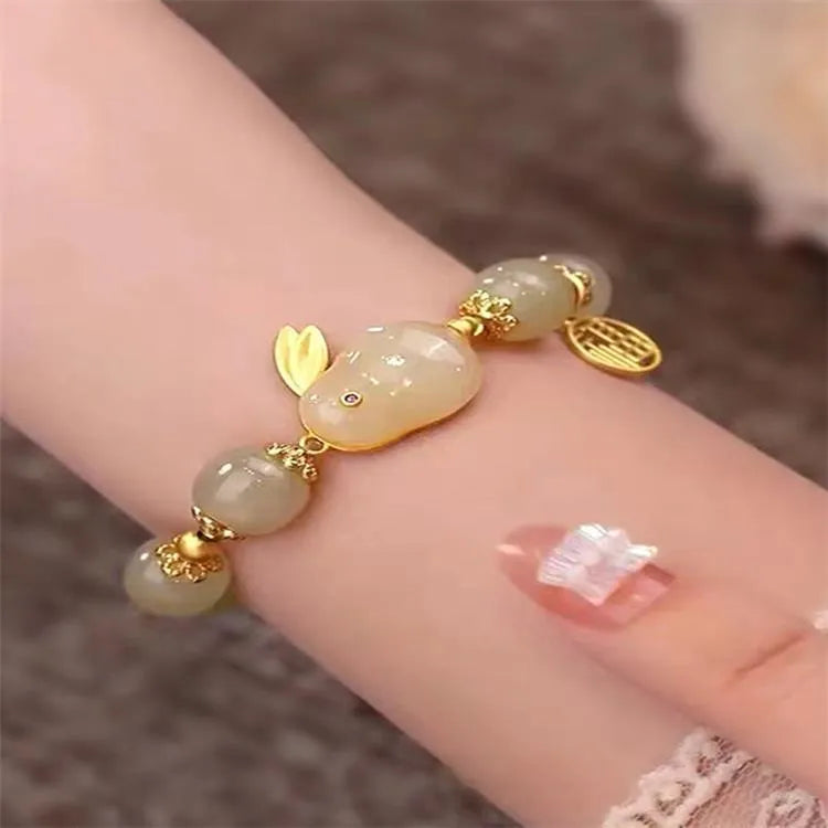 Green jade women's bracelet with a sculpted hare charm, engraved Fu character, and lily detailing