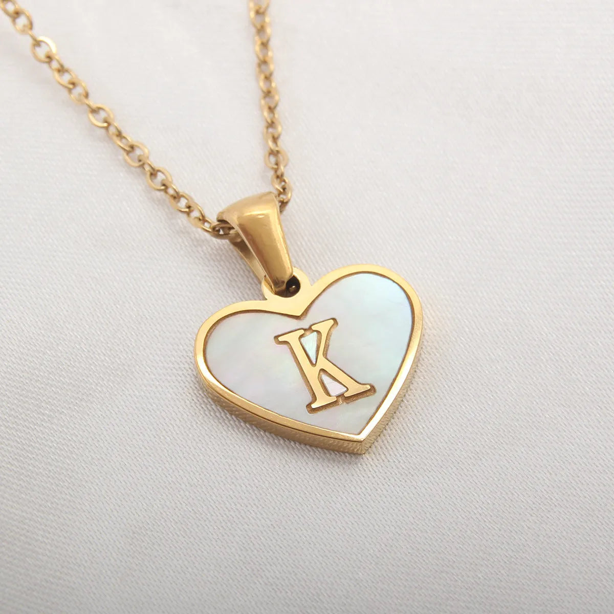 Gold plated heart-shaped necklace with white shell pendant on adjustable stainless steel chain