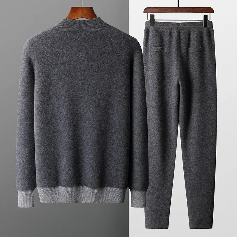Men's navy blue cashmere blend knitted cardigan suit with half turtleneck and zip, paired with matching trousers.
