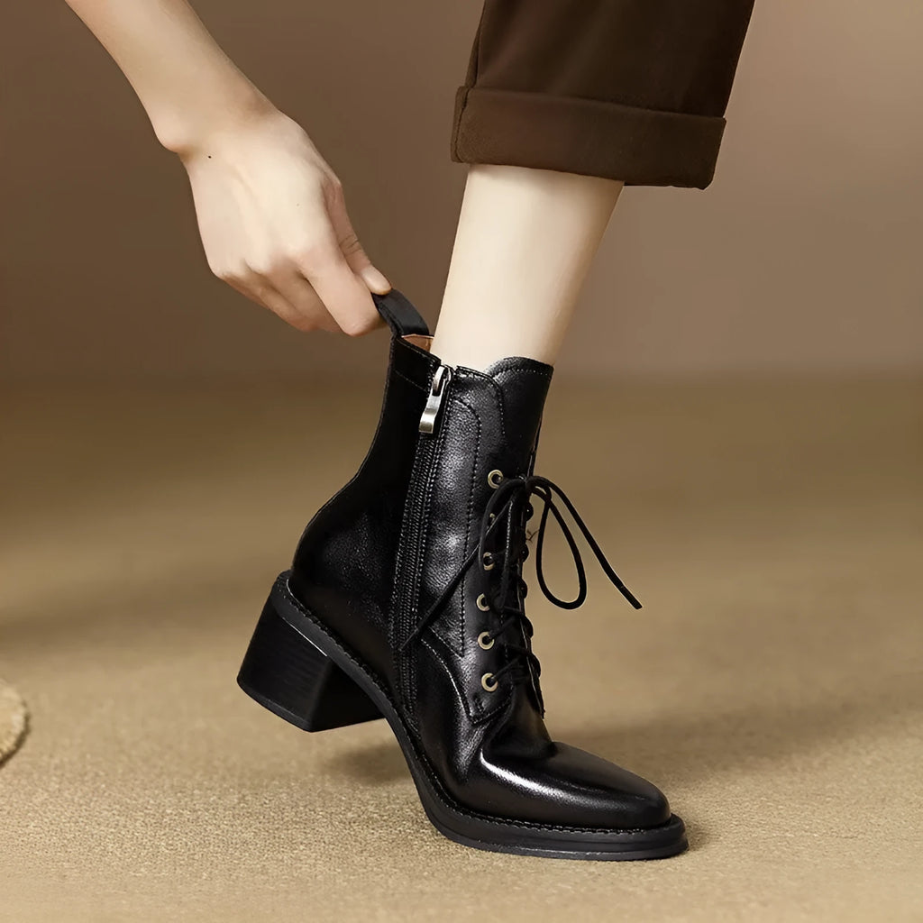 Women's black pointed-toe short ankle boots with a 5.5cm heel on a plain background.
