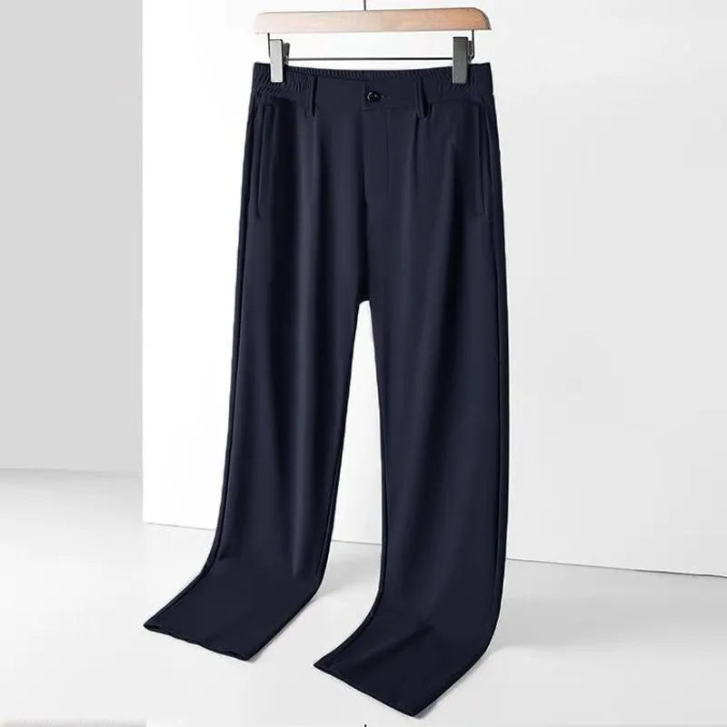 Man wearing black Ice Silk straight-leg loose trousers with an elasticated waist for leisure.