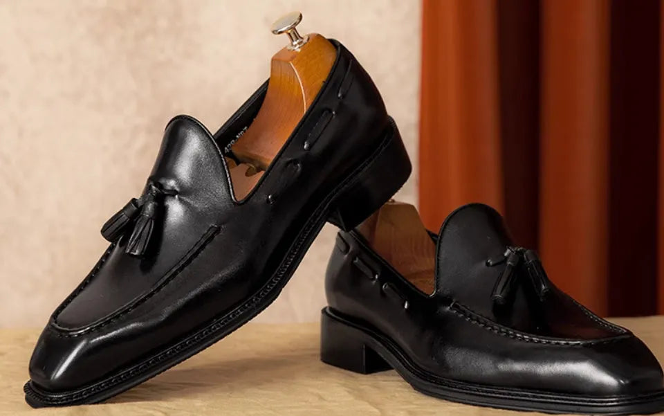 Men's black genuine leather slip-on loafers with a polished finish and rubber sole