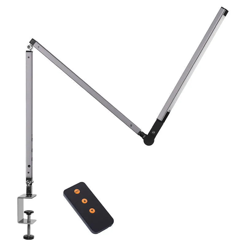 Folding aluminium desk lamp with a metal clip, shown in dazzling black, attached to a desk edge.