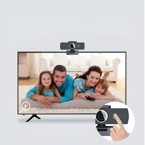 Black USB webcam with magnetic privacy cover on desk next to computer monitor