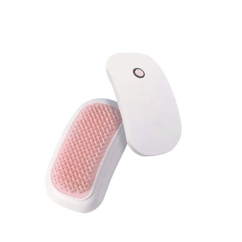 Pink handheld electric pet grooming brush with soft TPE teeth on a white background.