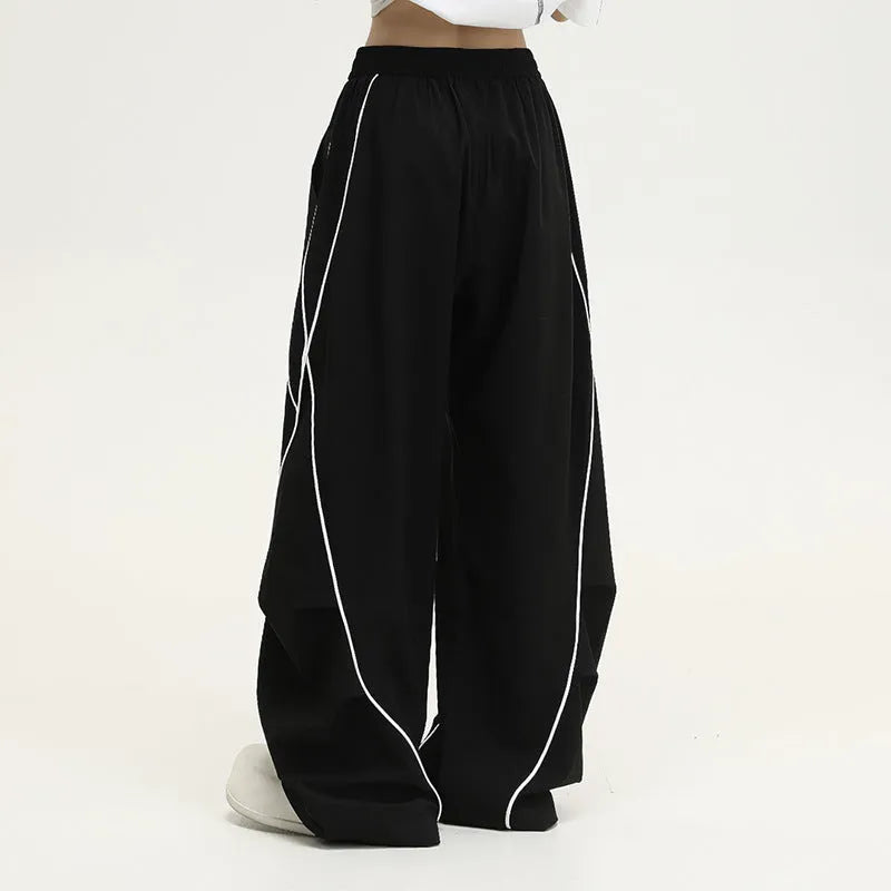 Black wide-leg trousers with vertical stripes and a pleated mid-waistband.