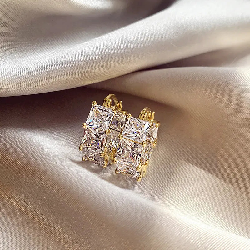 Geometric U-shaped gold earrings with round accents and black zircon stones
