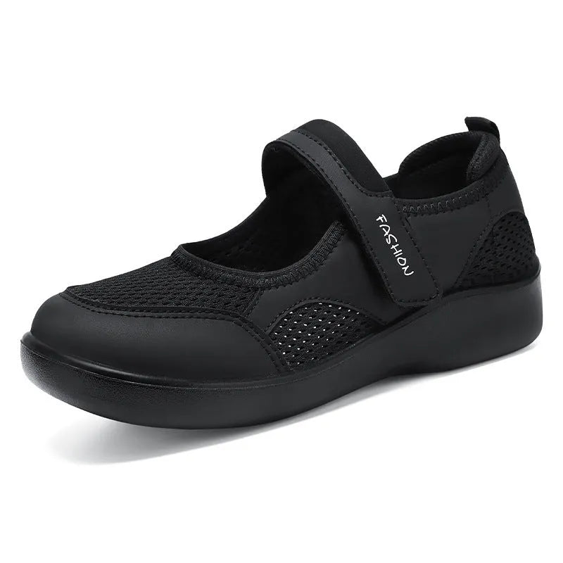 Women's grey mesh slip-on casual shoes with Velcro strap fastening on a flat sole.