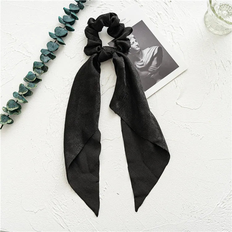 Spring dark green cloth hair accessory shaped as a large intestine ring, shown as a hair band.