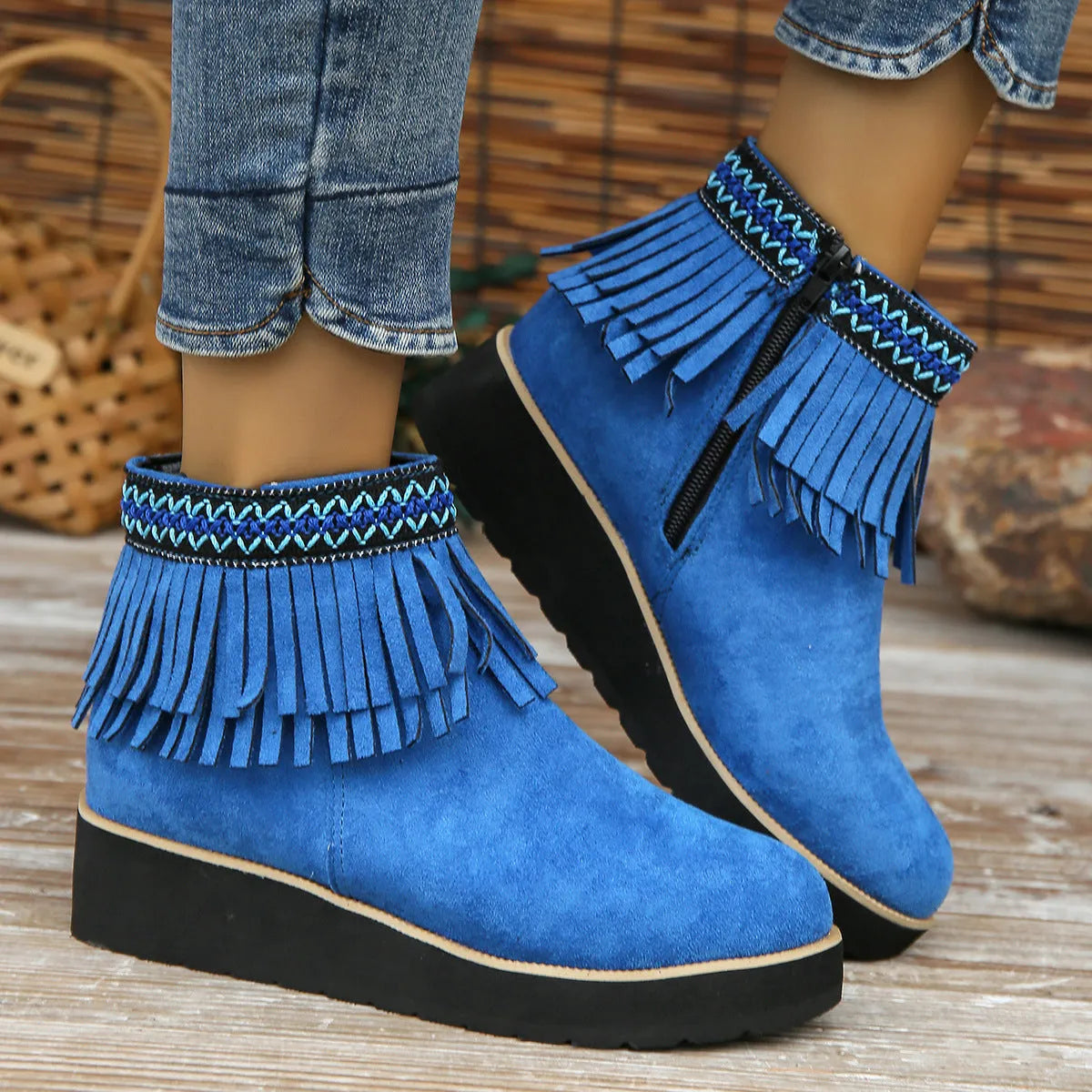 Women's suede ankle boot with wedge heel, side zipper, and tassel detail in dark brown.