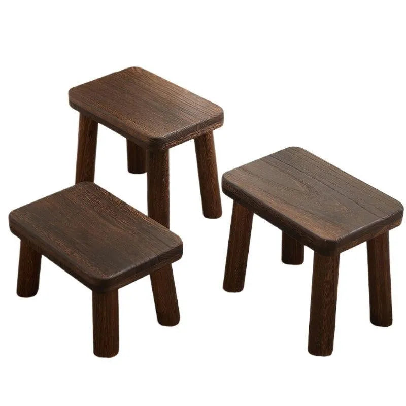Rustic distressed wooden changing stool with bracket structure for shoe removal.