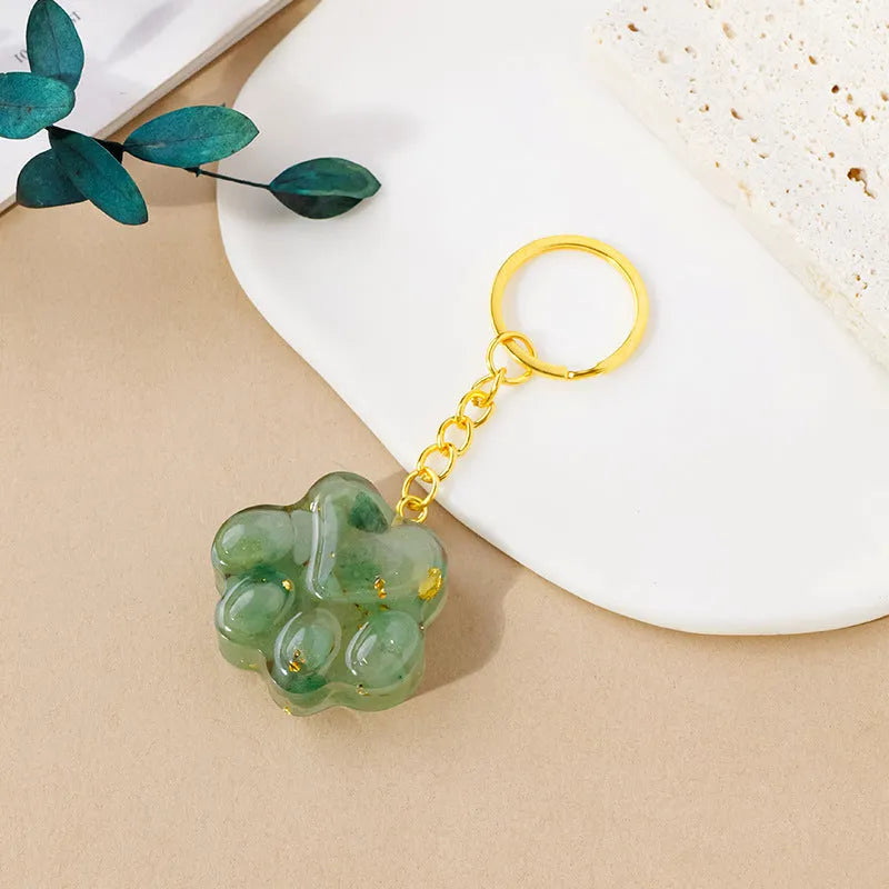 Natural crystal cat's paw shaped pendant on a silver keychain ring, shown in a random colour.