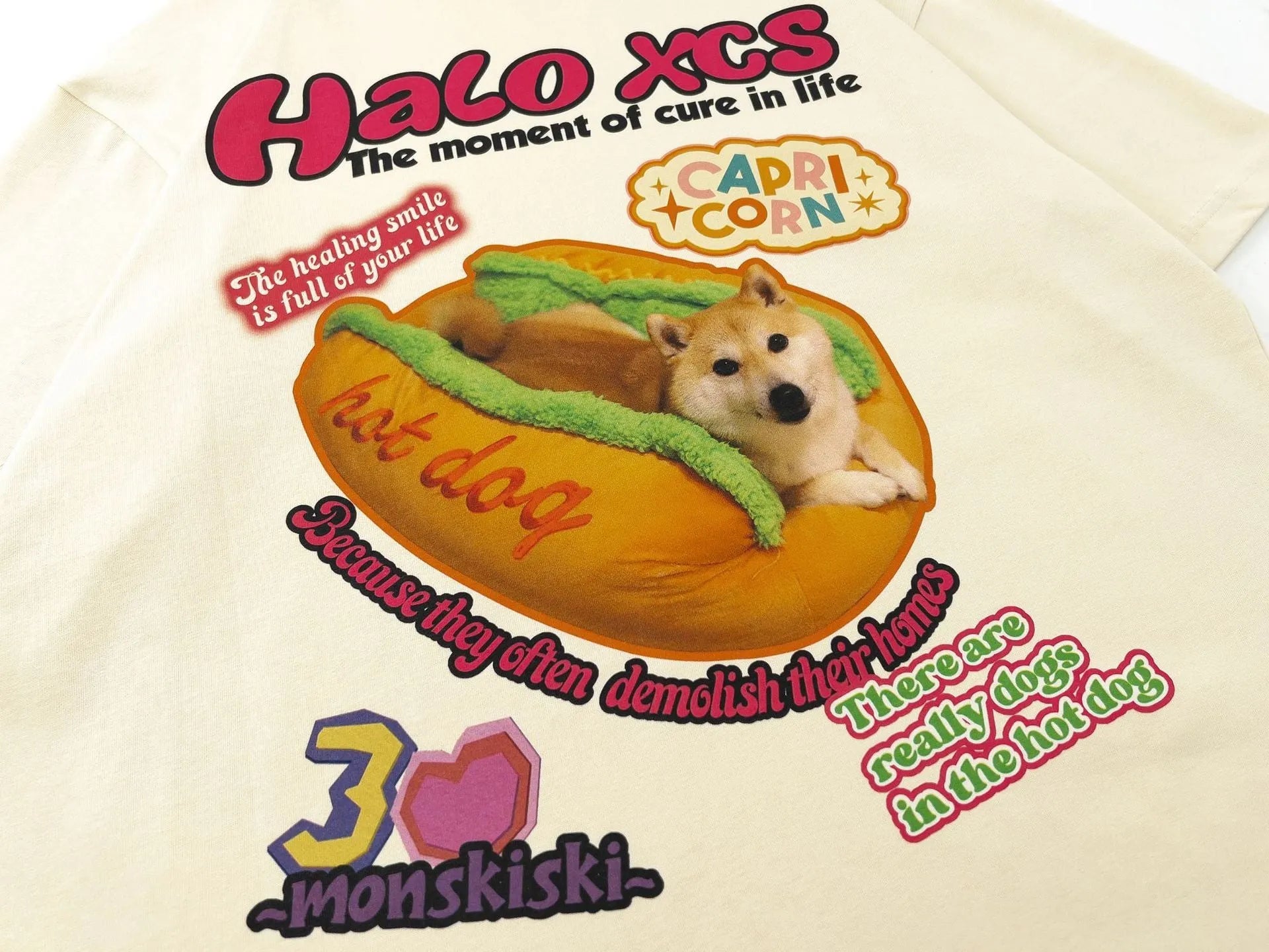 White short-sleeved cotton T-shirt with a cartoon print of a hamburger dog, showing a round neck and loose fit.