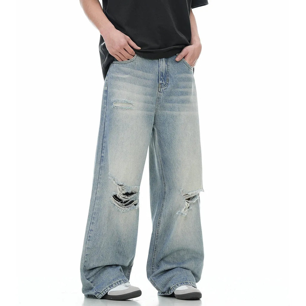 Blue men's straight-leg jeans with ripped detailing on the legs, showing a zipper fly.