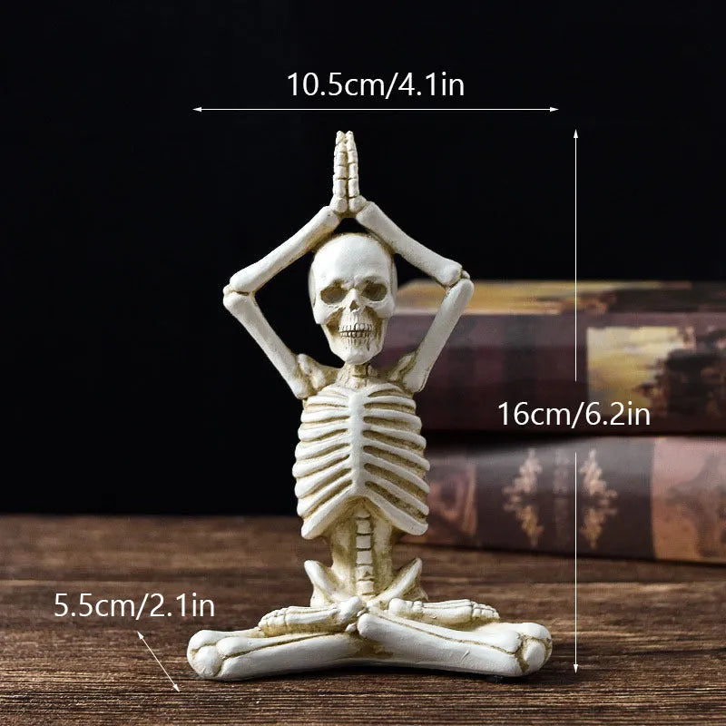 Detailed resin ornament of a yoga pose skeleton skull on a desktop, shown in black and white colour options.