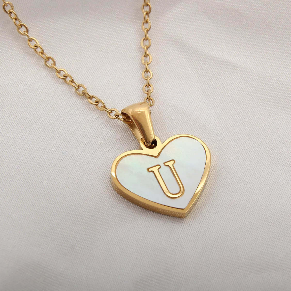 Gold plated heart-shaped necklace with white shell pendant on adjustable stainless steel chain