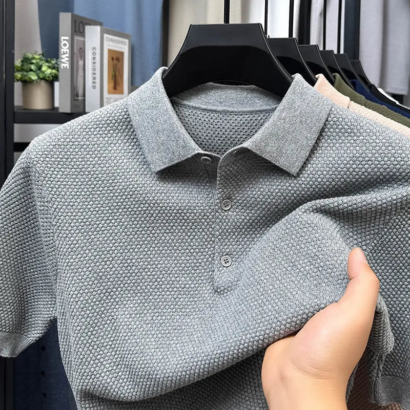 Man wearing a loose fit short sleeve cotton sweater in grey, showing the pullover style and relaxed silhouette.