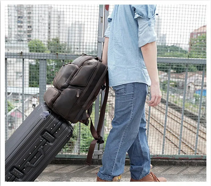 Dark brown genuine leather 17-inch laptop backpack with double shoulder straps and embossed finish