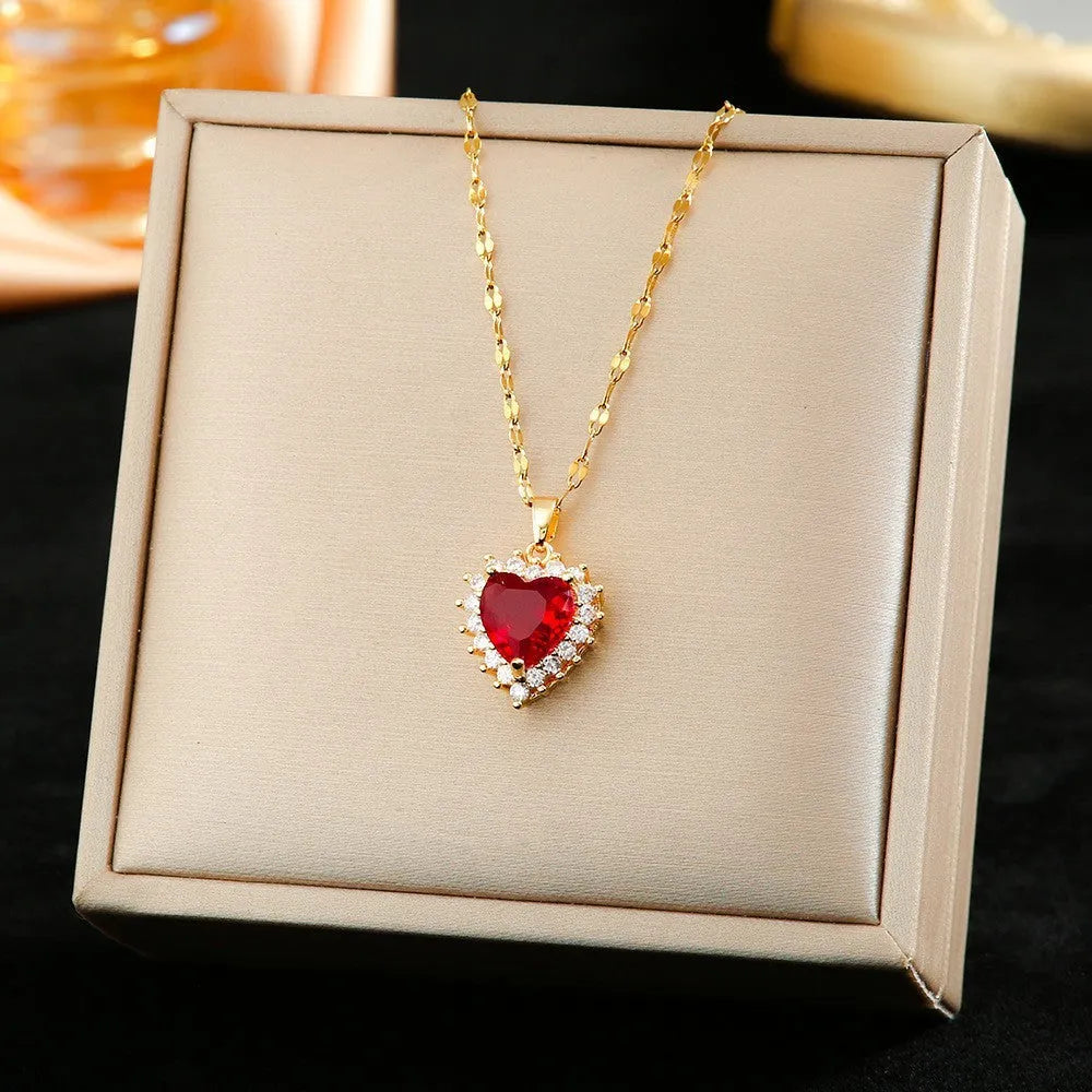 Women's heart-shaped jewellery set with matching necklace, stud earrings, and ring in electroplated gold red finish