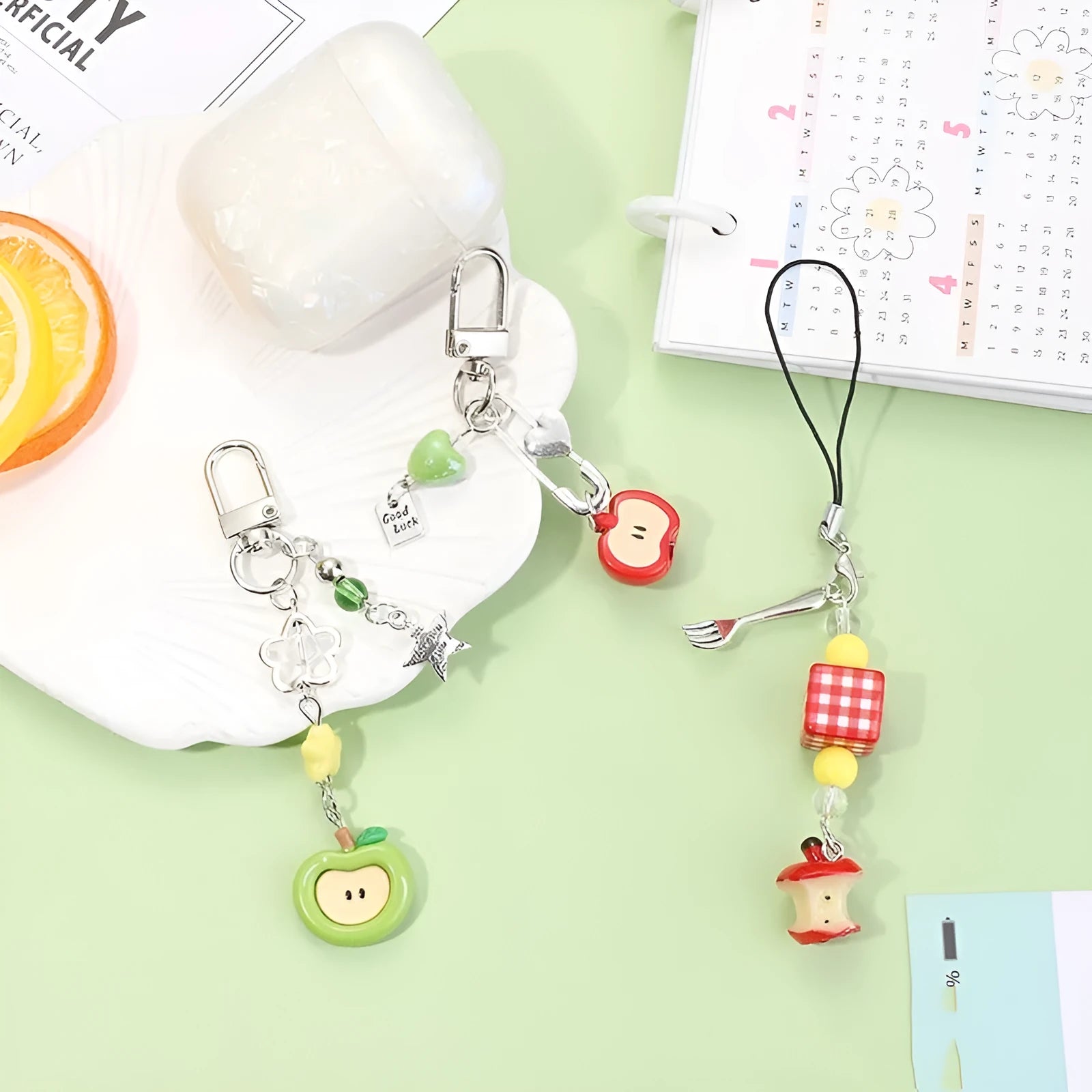 Plastic resin fruit charm keychain with removable rope in strawberry, green apple, and red apple designs.