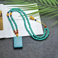 Turquoise stone pendant with hand-woven mesh flower design on a ball bead necklace chain.