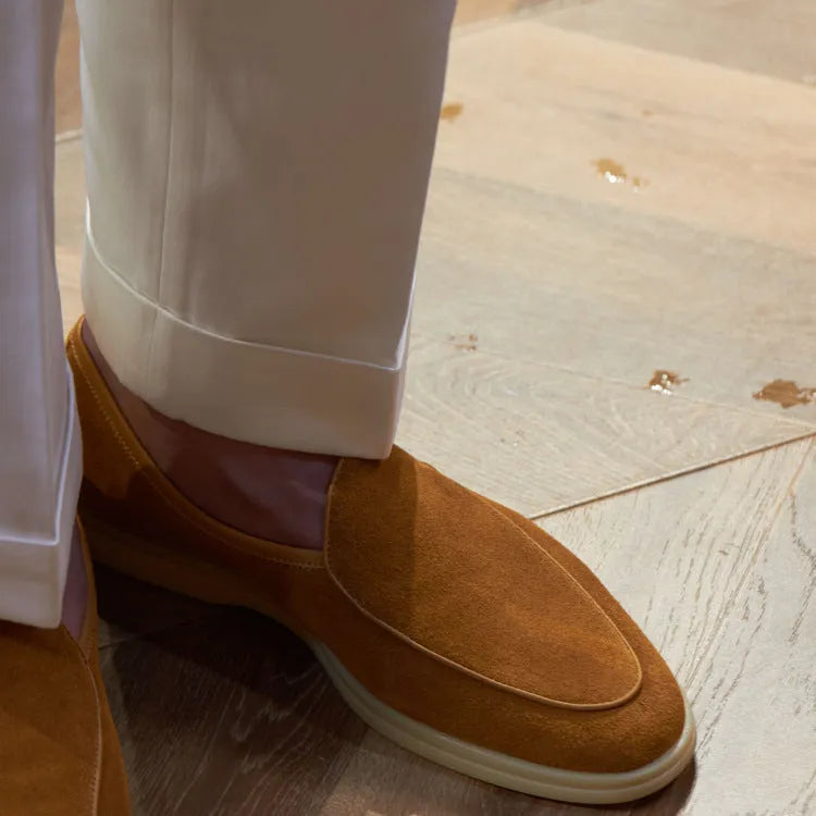 Men's brown genuine leather flat loafers with a low cut and TPR sole on a light background.