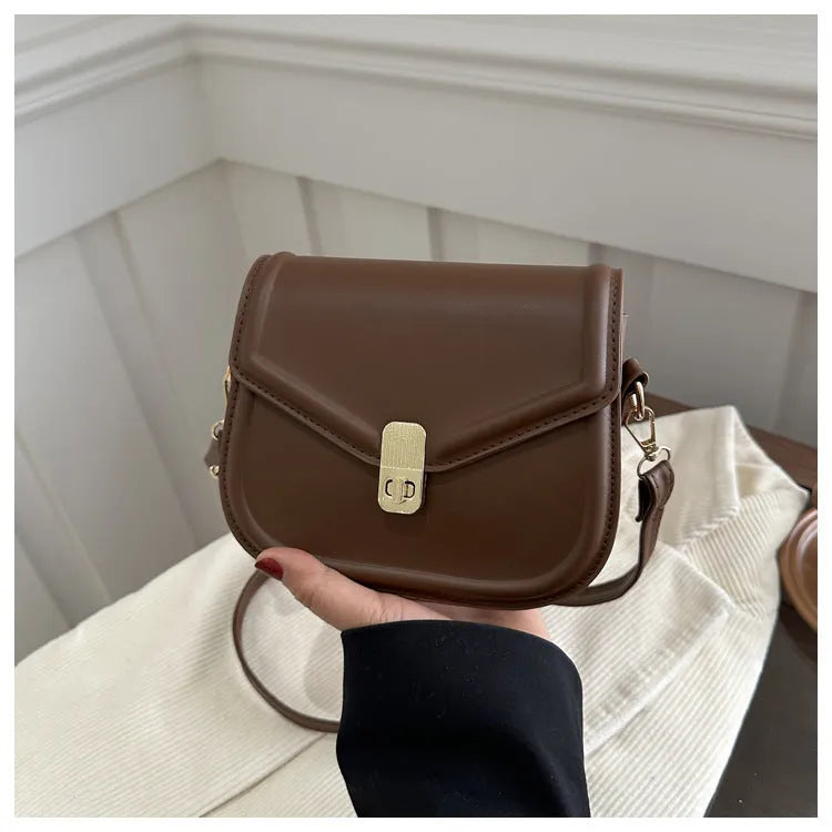 Soft textured PU shoulder messenger bag in horizontal square clamshell design.