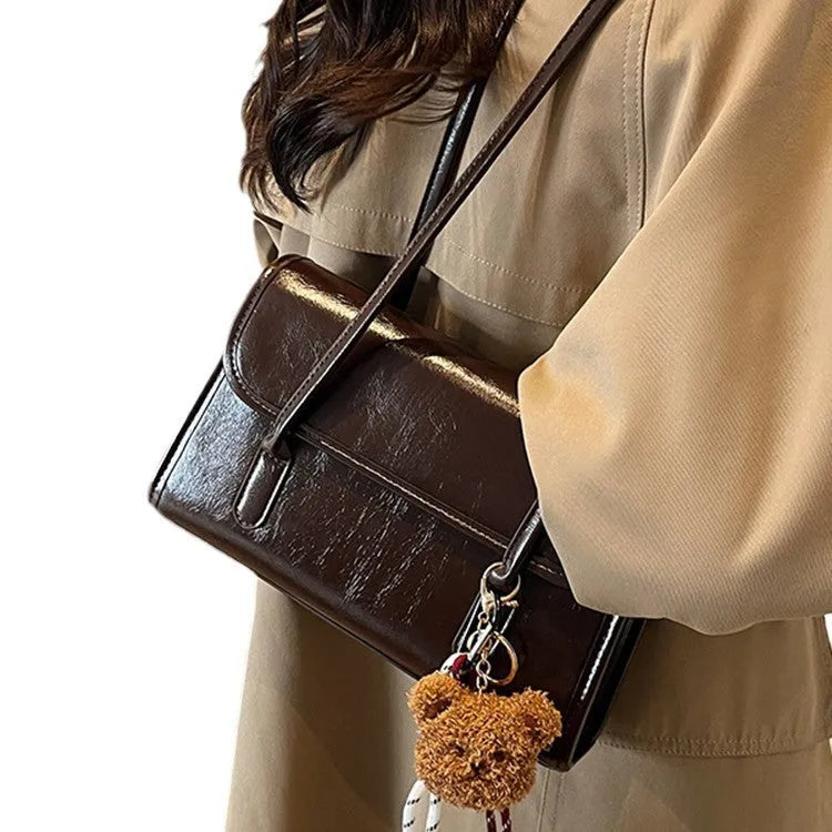 Women's brown PU leather shoulder bag with square shape, double straps, and decorative pendant attachment