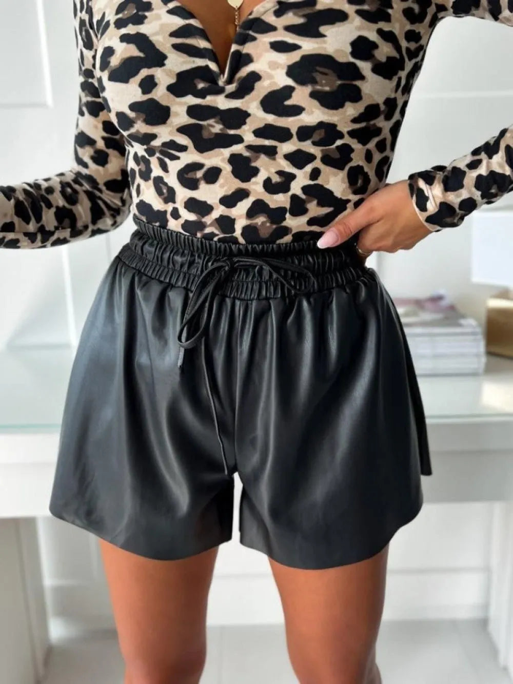 Women's black lace-up drawstring wide-leg shorts with a mid-waist and straight-leg design.