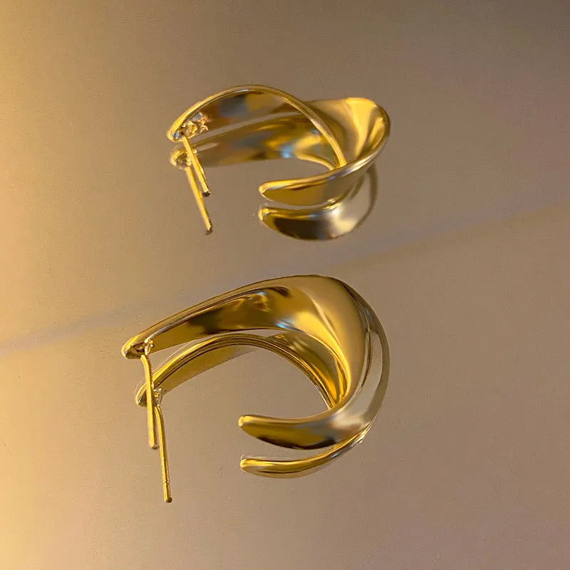 Gold and silver twisted geometric metal earrings with round shape and electroplated finish