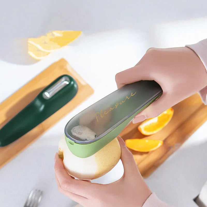 Dark green kitchen peeler with stainless steel blade inside a storage tube