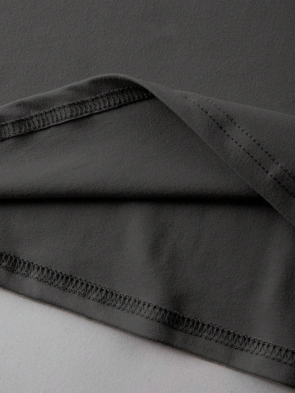 Loose fit cotton short sleeve T-shirt in black, green, grey, or orange on a hanger
