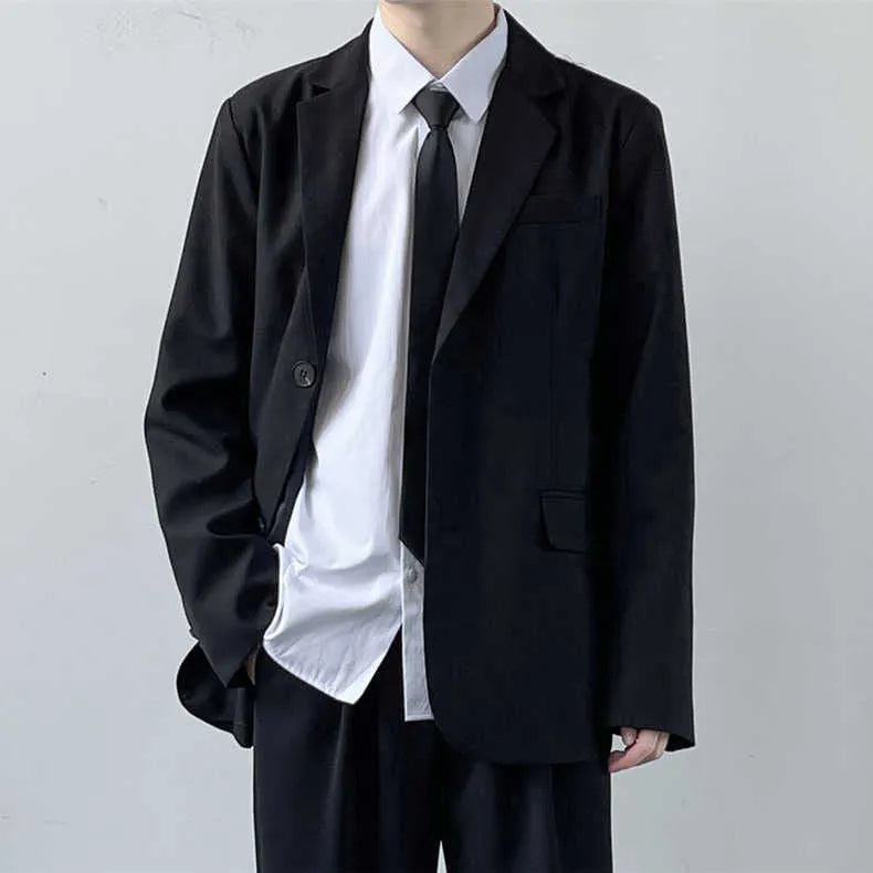 Plus size man modelling a loose fit black suit jacket and trousers with a white shirt and tie.