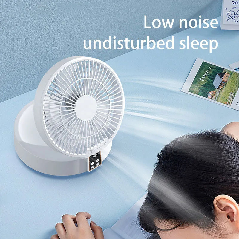 White portable USB rechargeable folding desk fan with remote control on wooden surface