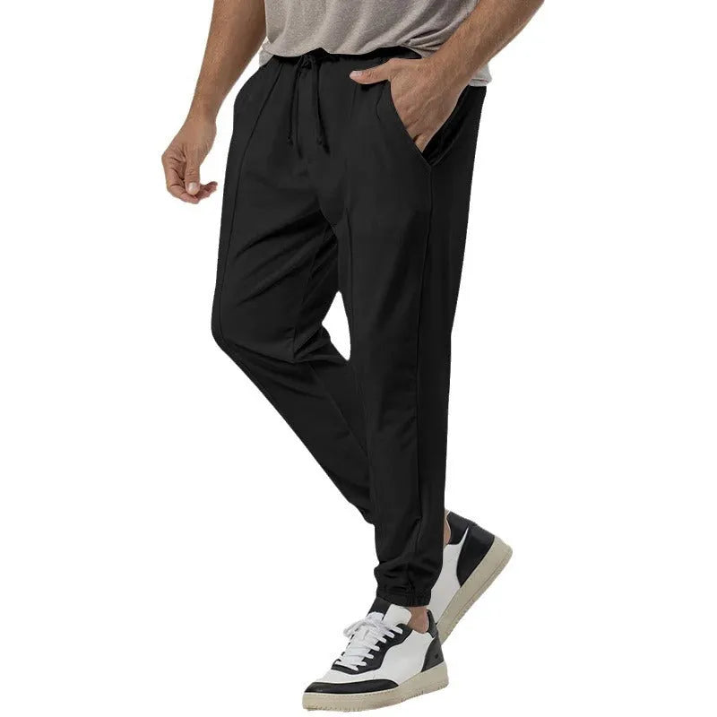 Men's grey loose-fit tapered track sweatpants with a straight leg on a neutral background.