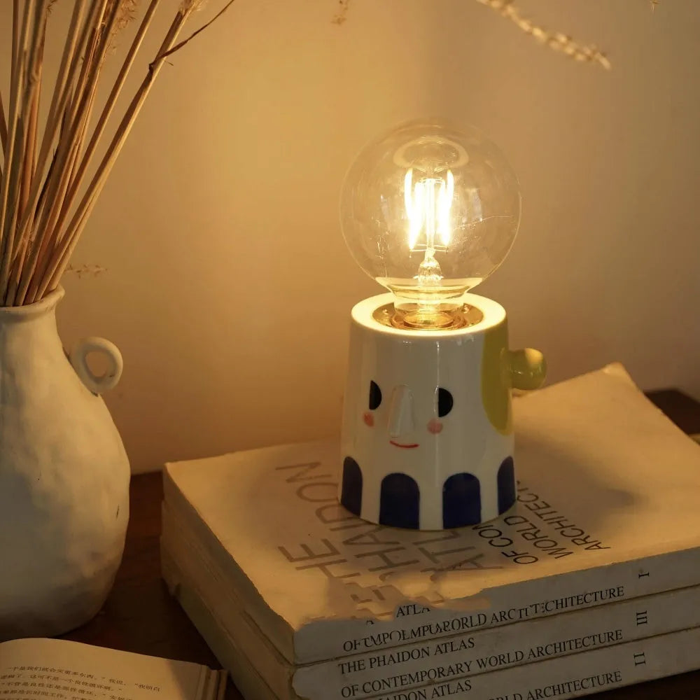 Handmade white ceramic bedside lamp with ball headlight design on wooden table