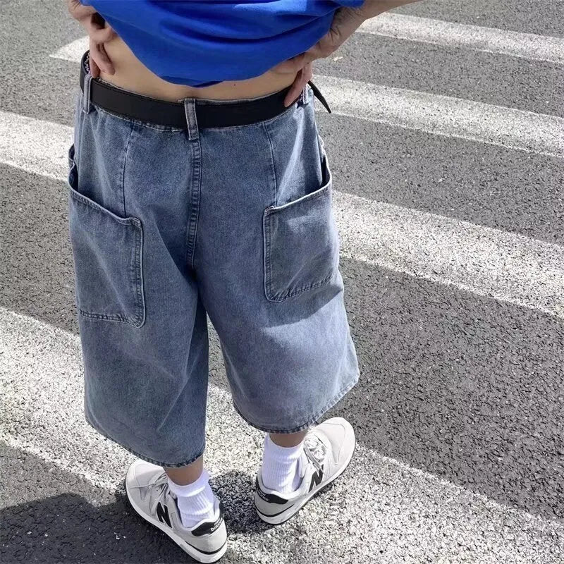 Man wearing blue washed denim shorts with a high waist, cropped leg, and straight cut.