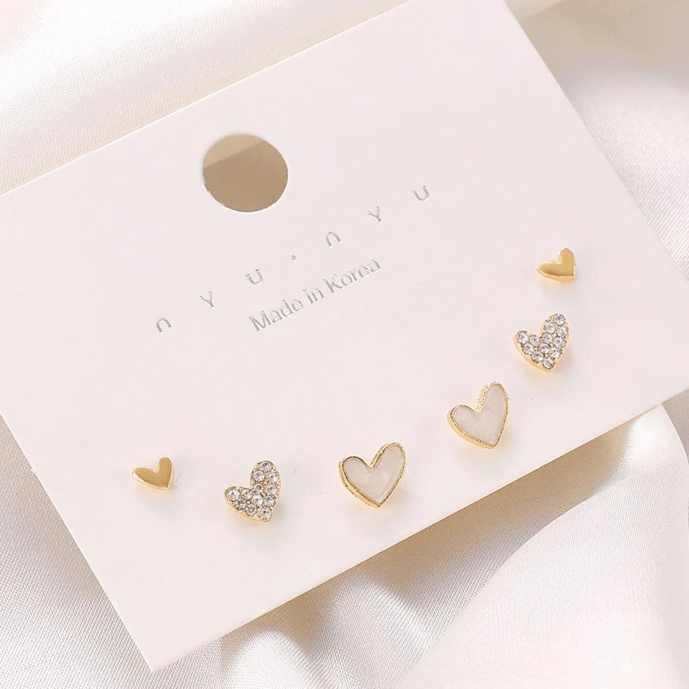 Three pairs of heart shape alloy earrings with electroplated gold, black, pink, and black-white colour options