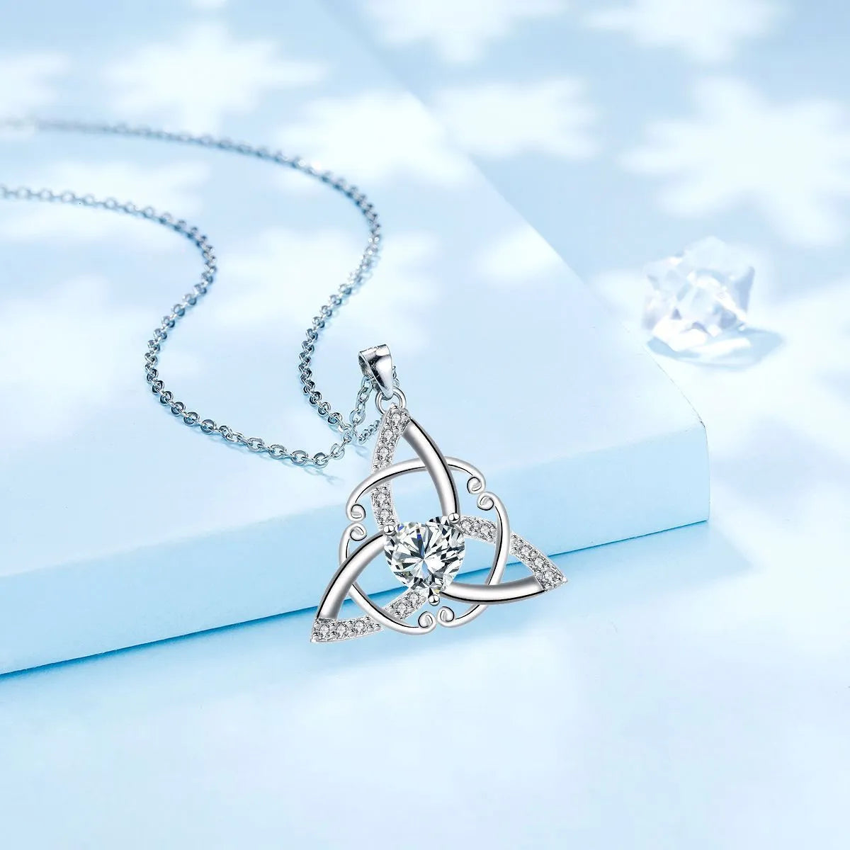 Close-up of a women's Celtic knot pendant necklace with geometric design in a choice of blue, lvzuan, red diamond or white diamond colour.
