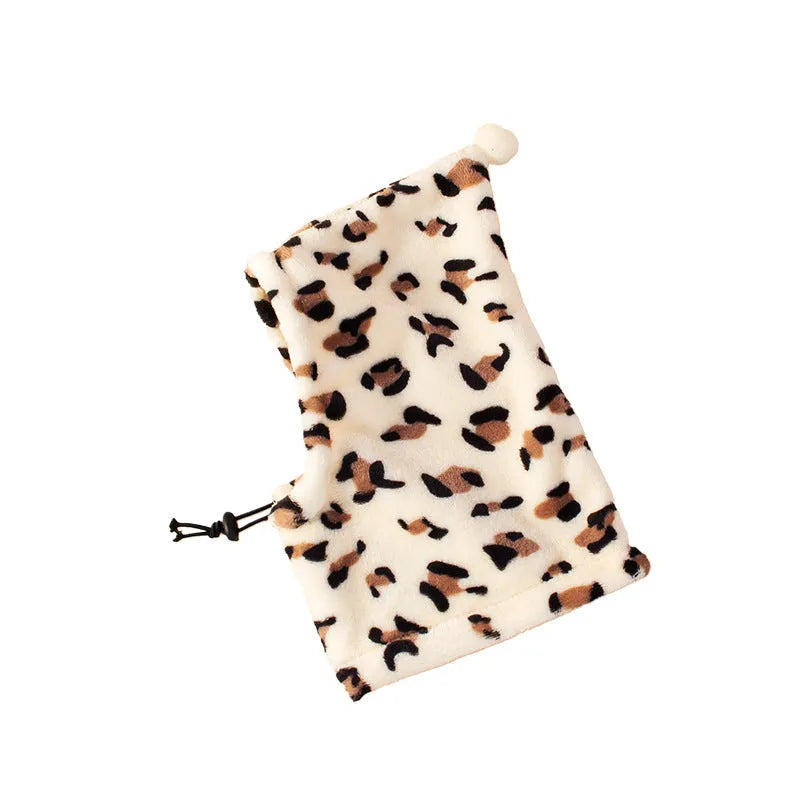 A dog or cat wearing a soft cloth bear headdress hat with upright rabbit ears, in leopard print colour.
