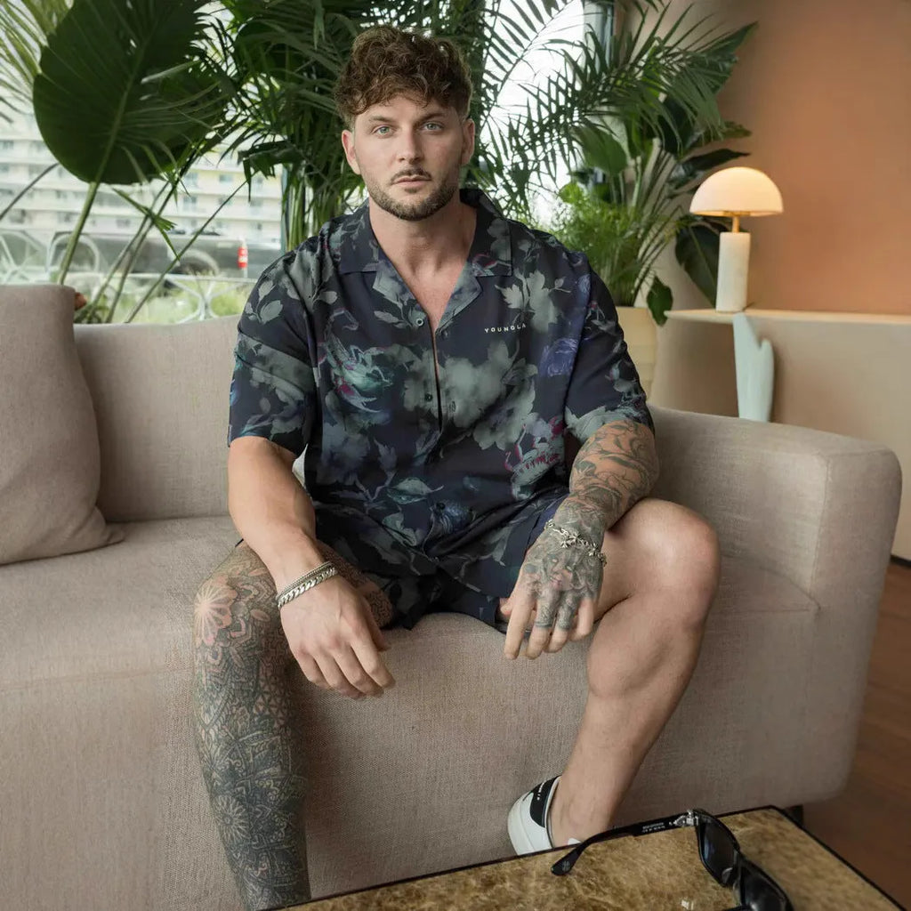 Man wearing a loose-fit, short sleeve floral print top in a neutral colour.