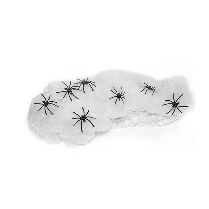 White cotton spider web Halloween decoration with multiple attached spiders draped over a surface.