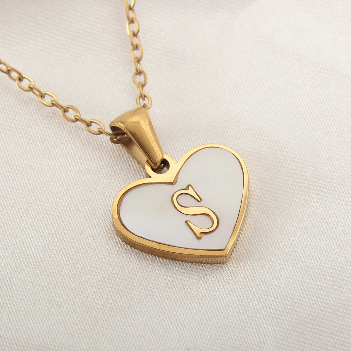 Gold plated heart-shaped necklace with white shell pendant on adjustable stainless steel chain