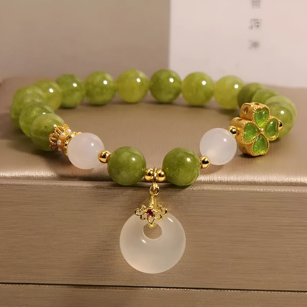 Green tourmaline four-leaf clover women's bracelet with safety buckle clasp on a white background.