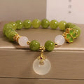 Green tourmaline four-leaf clover women's bracelet with safety buckle clasp on a white background.