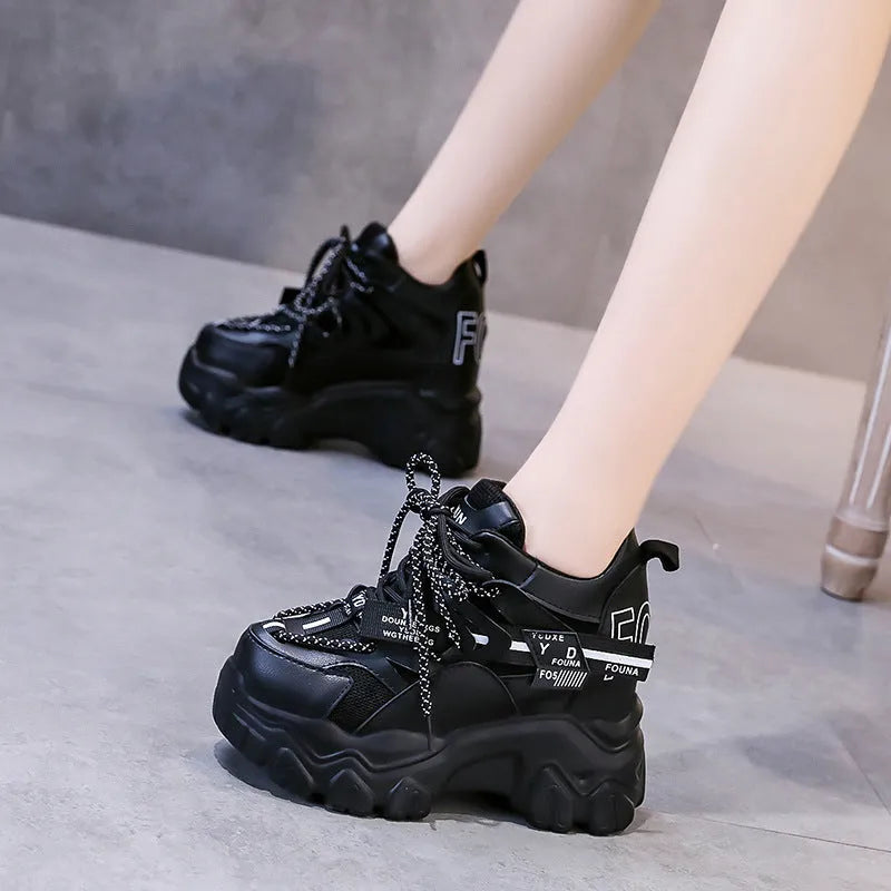White and black women's mesh platform sports shoes with cross-strap and rubber sole.