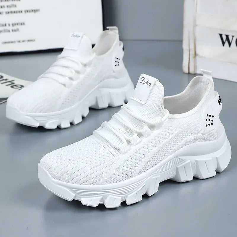 Men's white Flyknit sneakers with a thick PVC sole and round toe on a plain background.