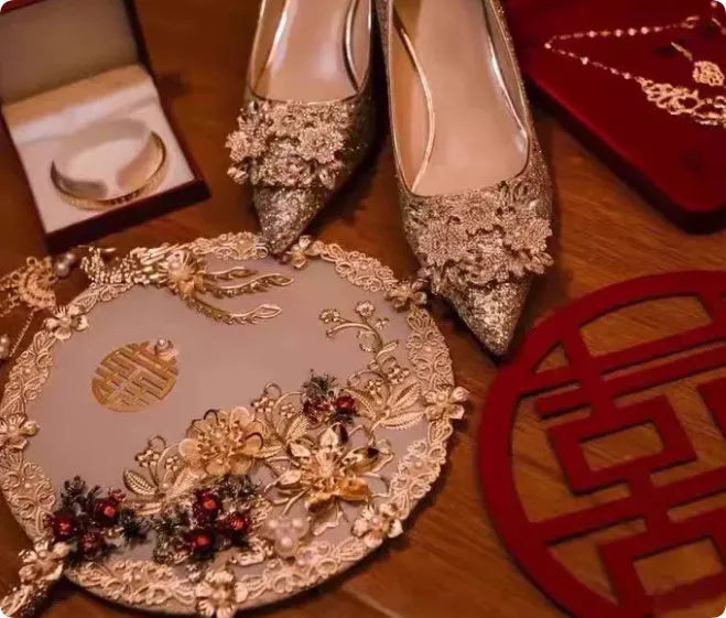 Champagne coloured bridal shoes with pointed toe, fine heel, and rhinestone floral decoration.