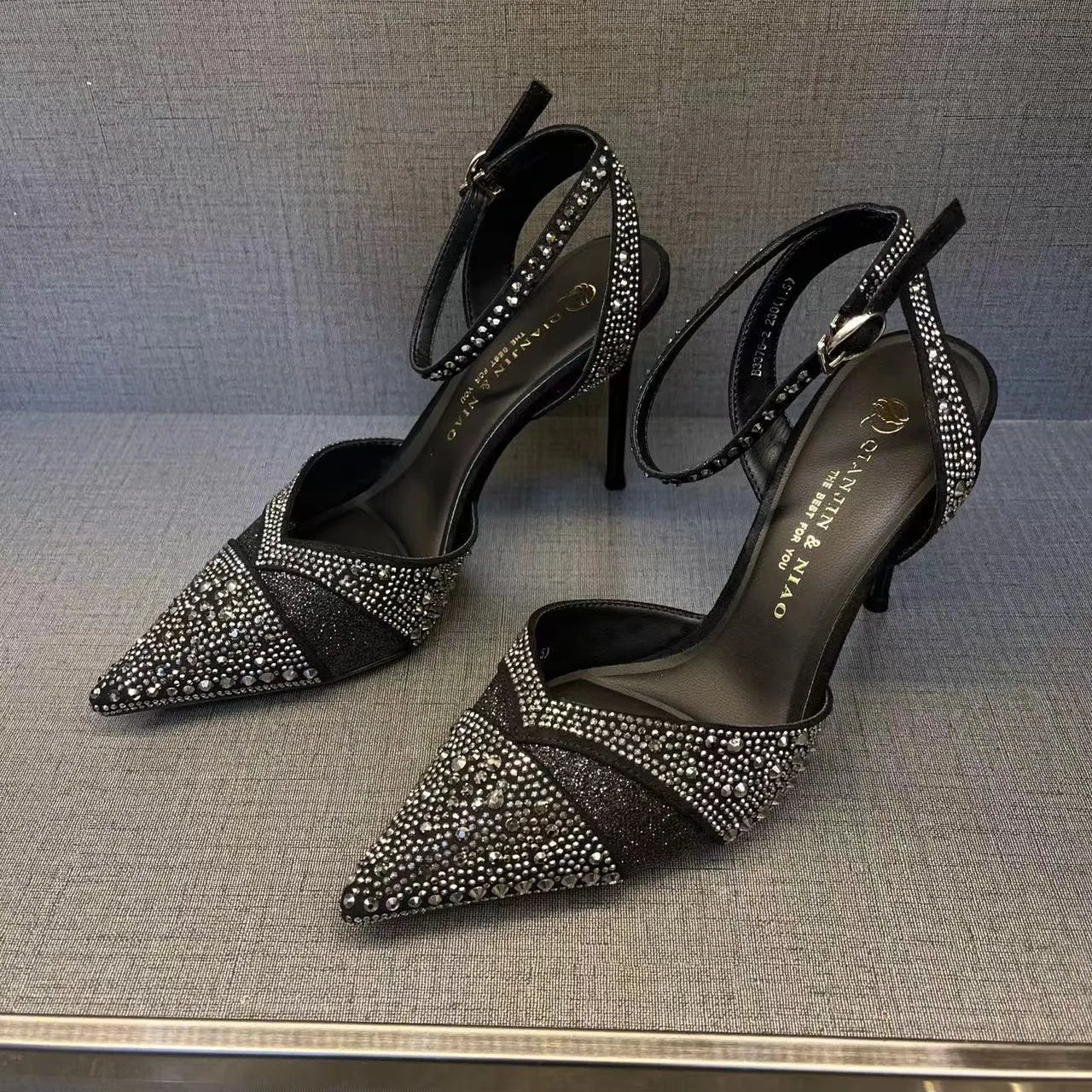 Women's silver hollow stiletto heels with pointed toe and red sole on white background